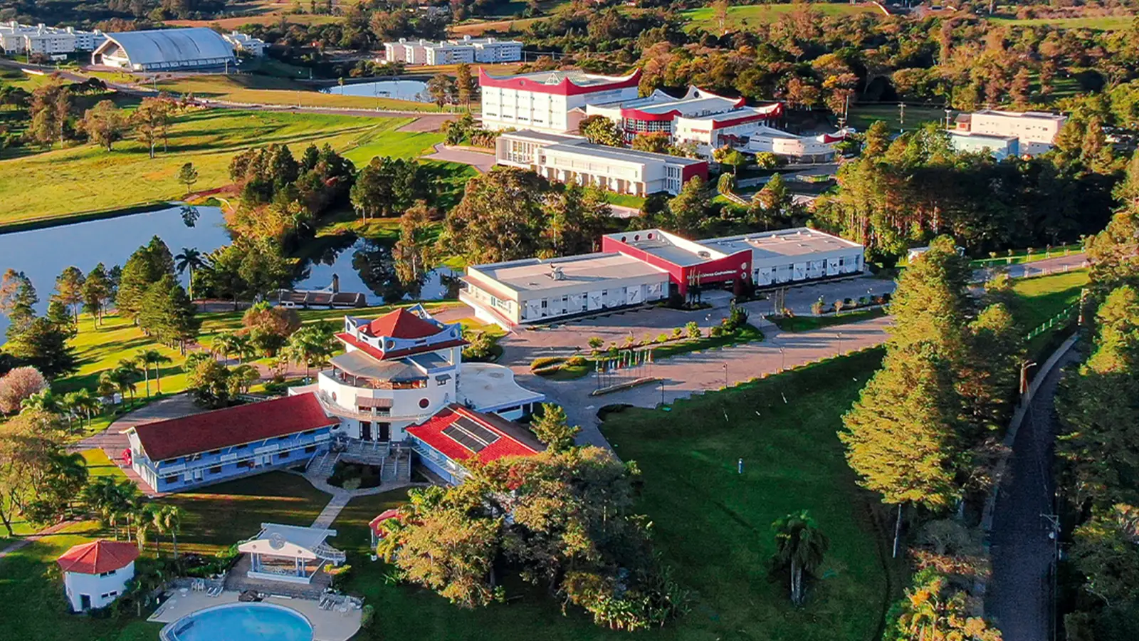 Vista aérea do campus do Recanto Maestro, entre lagos e a serra gaúcha